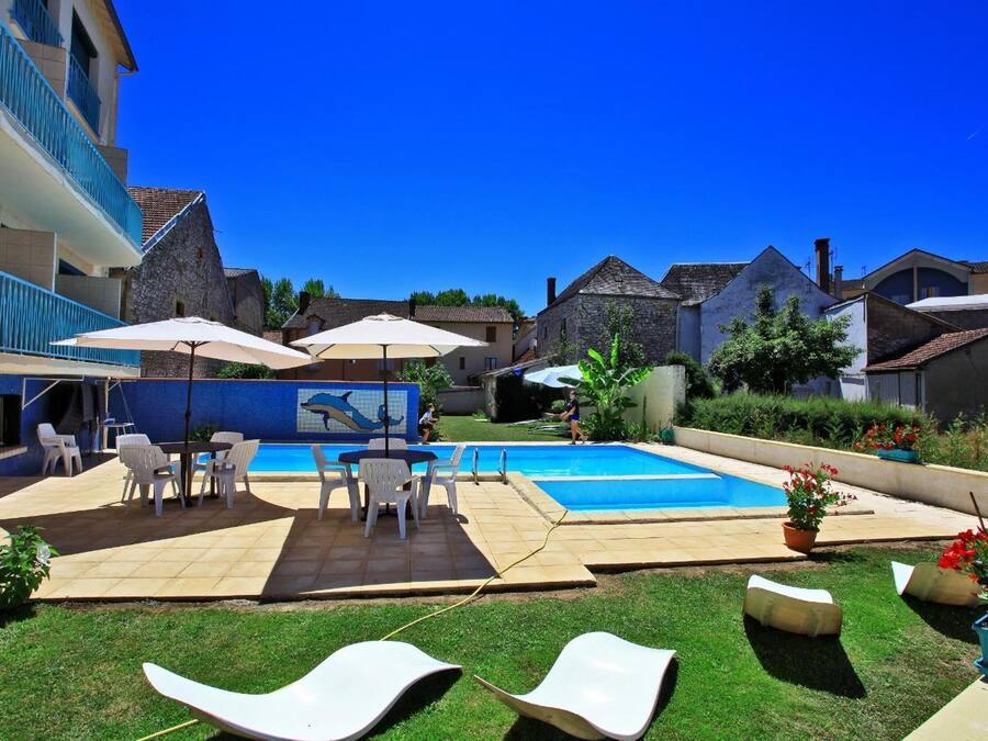 Una piscina al aire libre, sillones reclinables de piscina