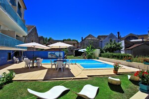 Una piscina al aire libre, sillones reclinables de piscina