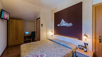 Una camera da letto con un letto, una scrivania e un computer.