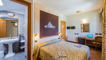 Habitación cuádruple | Minibar, caja de seguridad en la habitación y escritorio