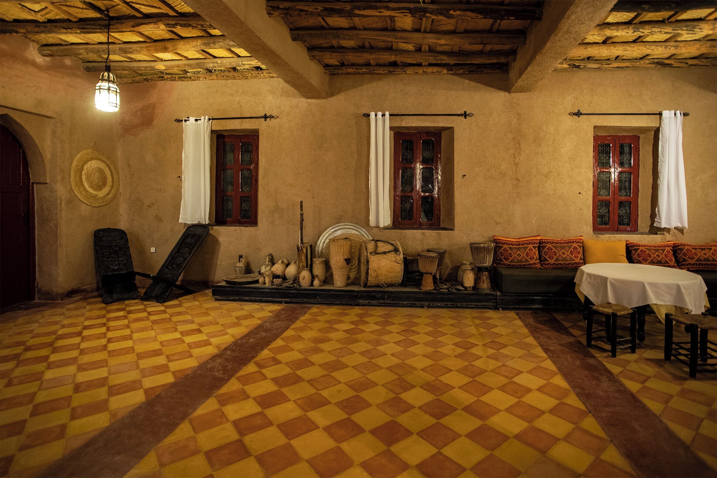 A room with a checkered floor, wooden furniture, and a fireplace.