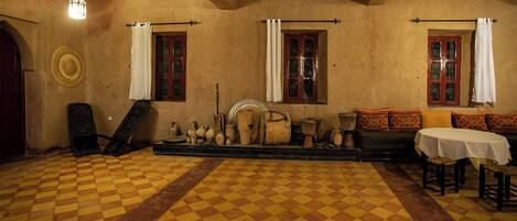 A room with a checkered floor, wooden furniture, and a fireplace.