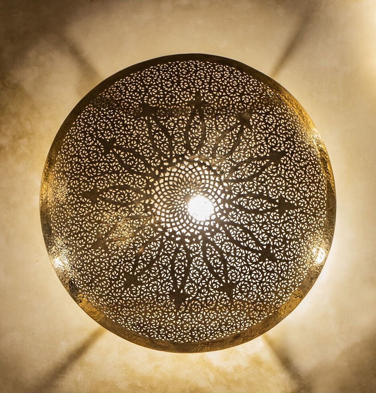 A circular ceiling light fixture with intricate geometric patterns.