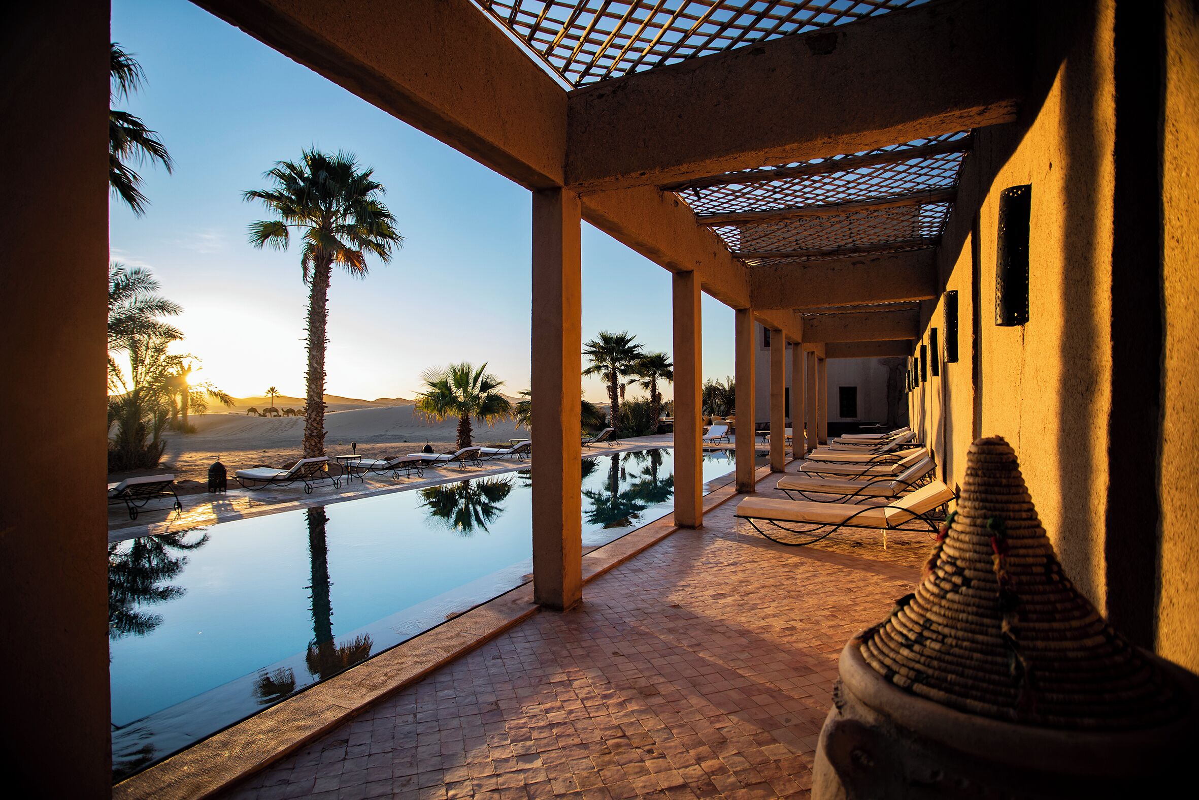 Een buitenzwembad, ligstoelen bij het zwembad