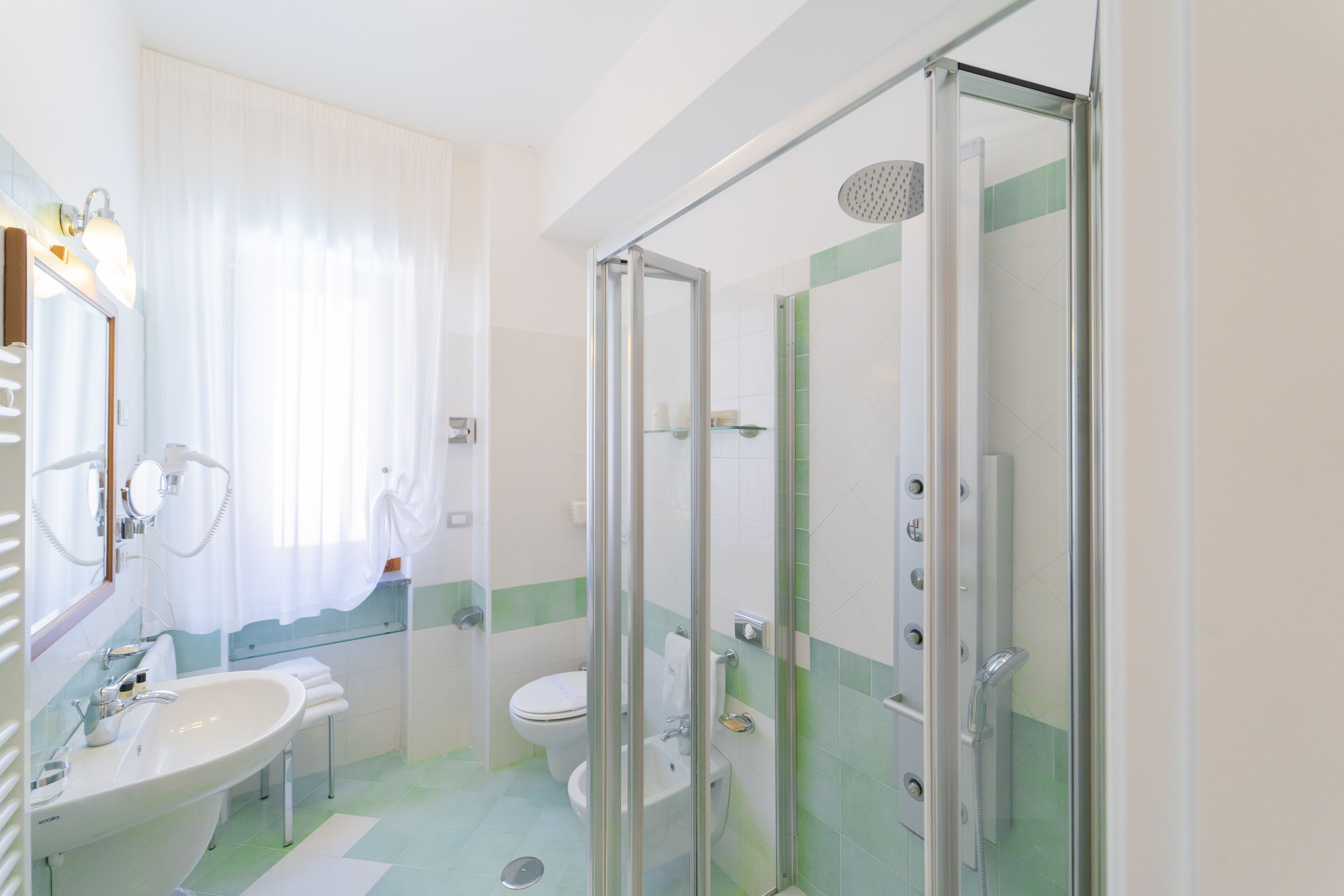 A modern bathroom with a glass-enclosed shower, a sink, and a toilet.
