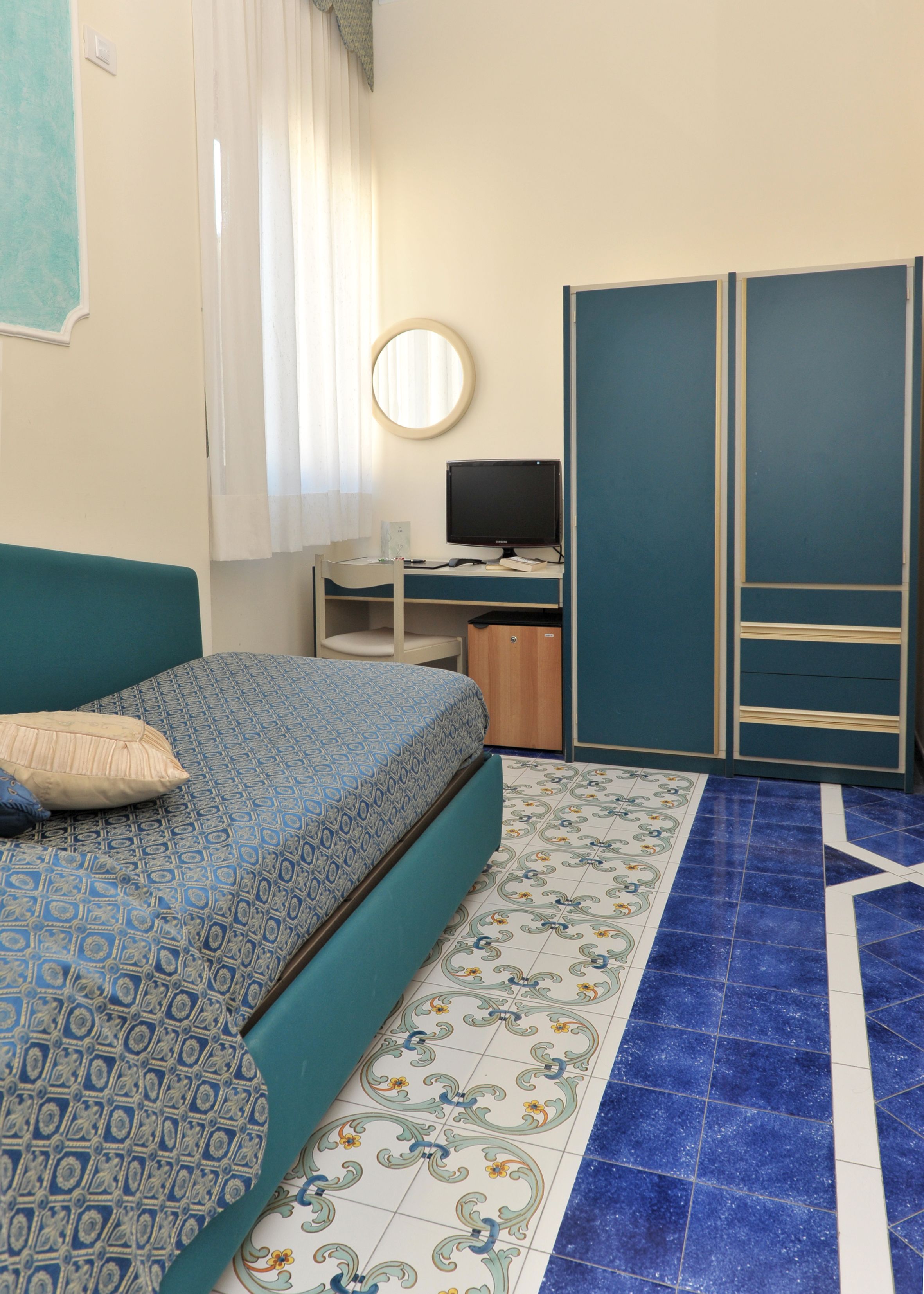 Un dormitorio con cama, escritorio, ordenador y armario.