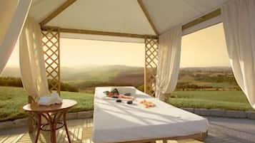Relax under a shaded canopy with a comfortable bed and a serene view of the surrounding landscape.
