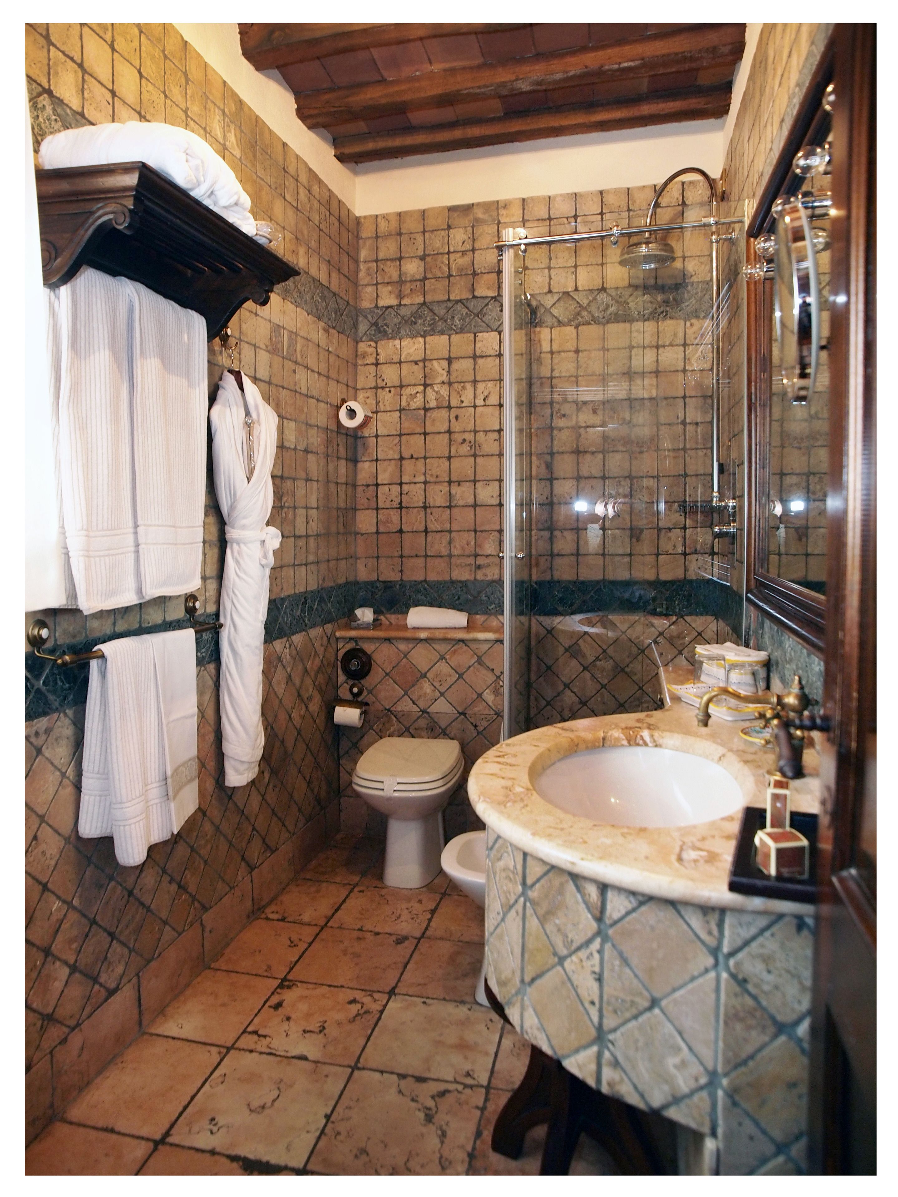 A bathroom with a shower, toilet, and sink.