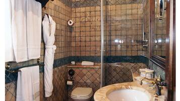 A bathroom with a shower, toilet, and sink.