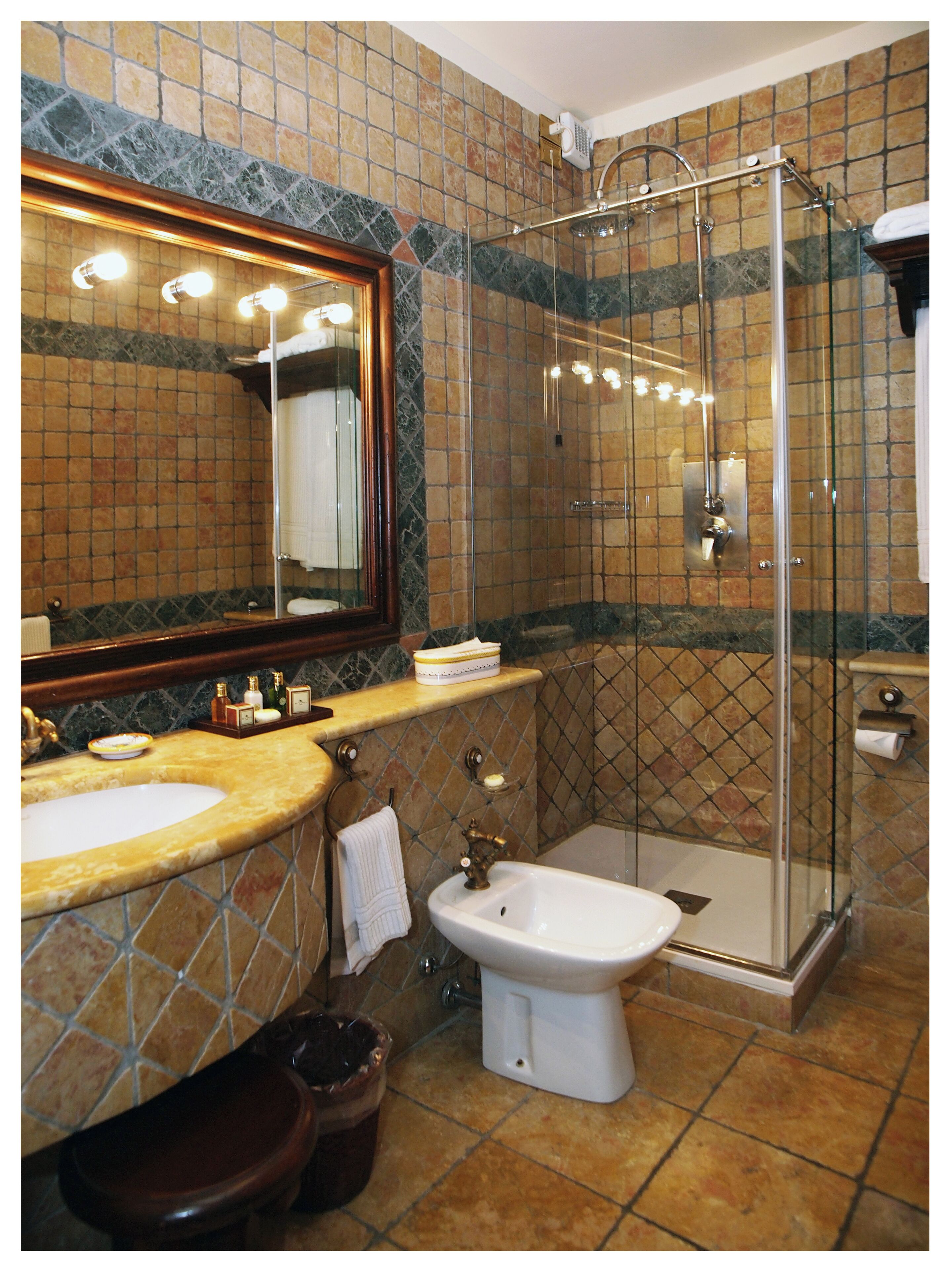 Ein Badezimmer mit Waschbecken, Spiegel, Dusche und Toilette.