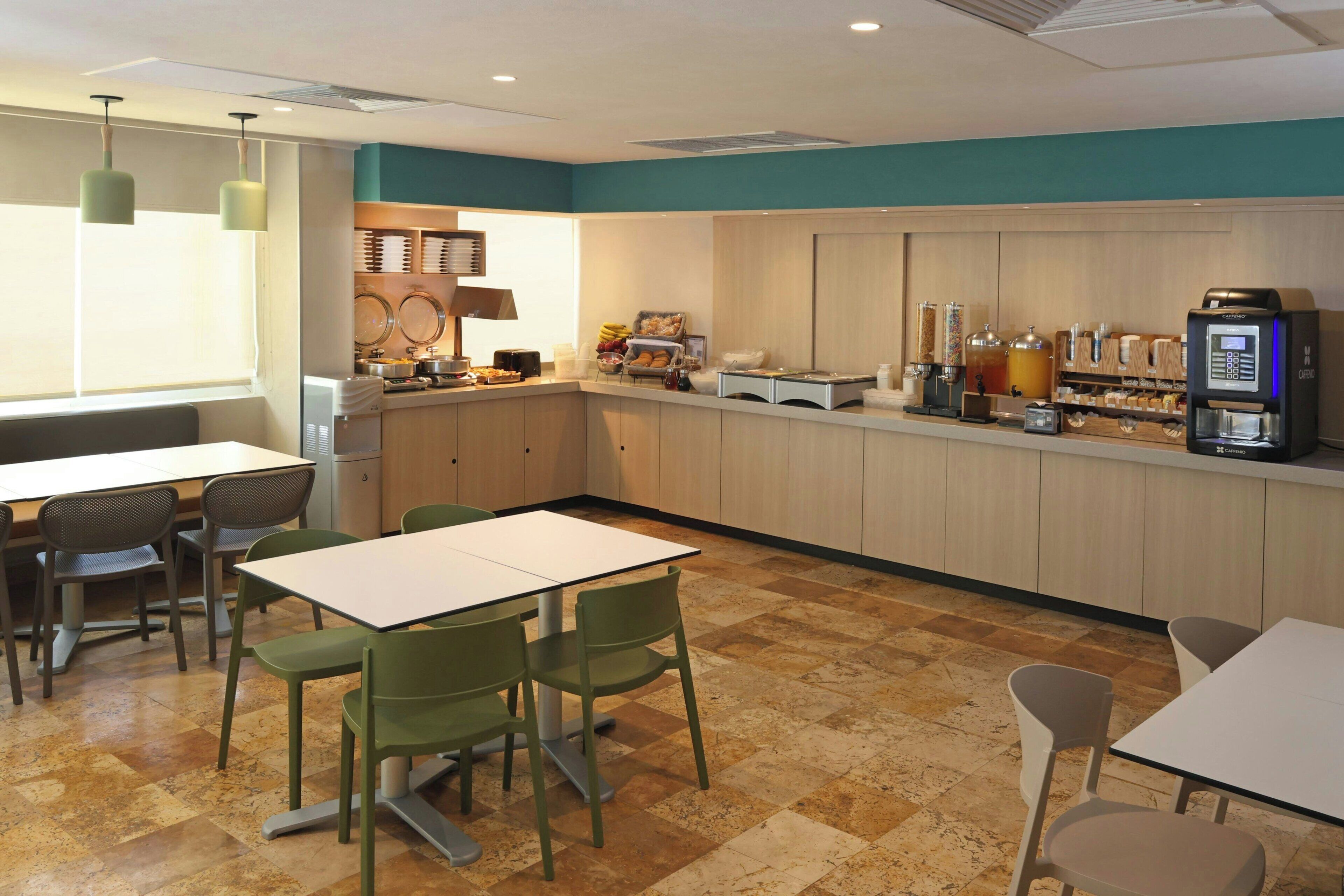 Un café moderne avec un long comptoir, un espace salon et une machine à café.