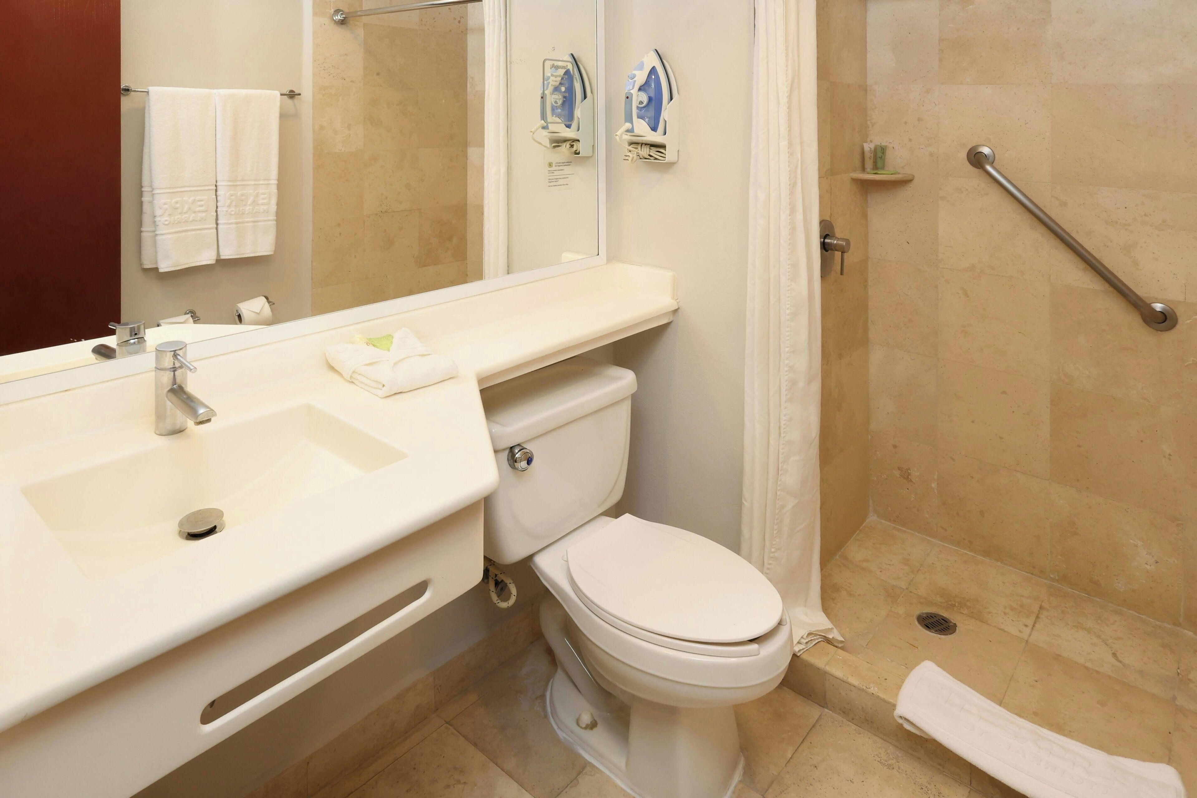 A bathroom with a sink, toilet, and shower.