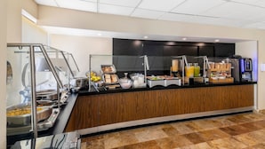 A buffet area with various food stations, including a self-service station with bowls of food, a juice dispenser, and a coffee machine. - City Express by Marriott Cancun (Cancun)