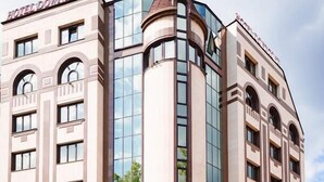 A hotel with a modern design, featuring a prominent corner tower and a glass facade. - Hotel Downtown (Sofia)