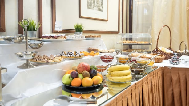 A buffet with various fruits, pastries, and a variety of dishes. - Hotel Downtown (Sofia)