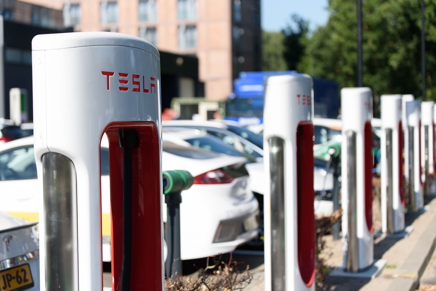 Een rij Tesla elektrische auto oplaadstations in een stedelijke omgeving.