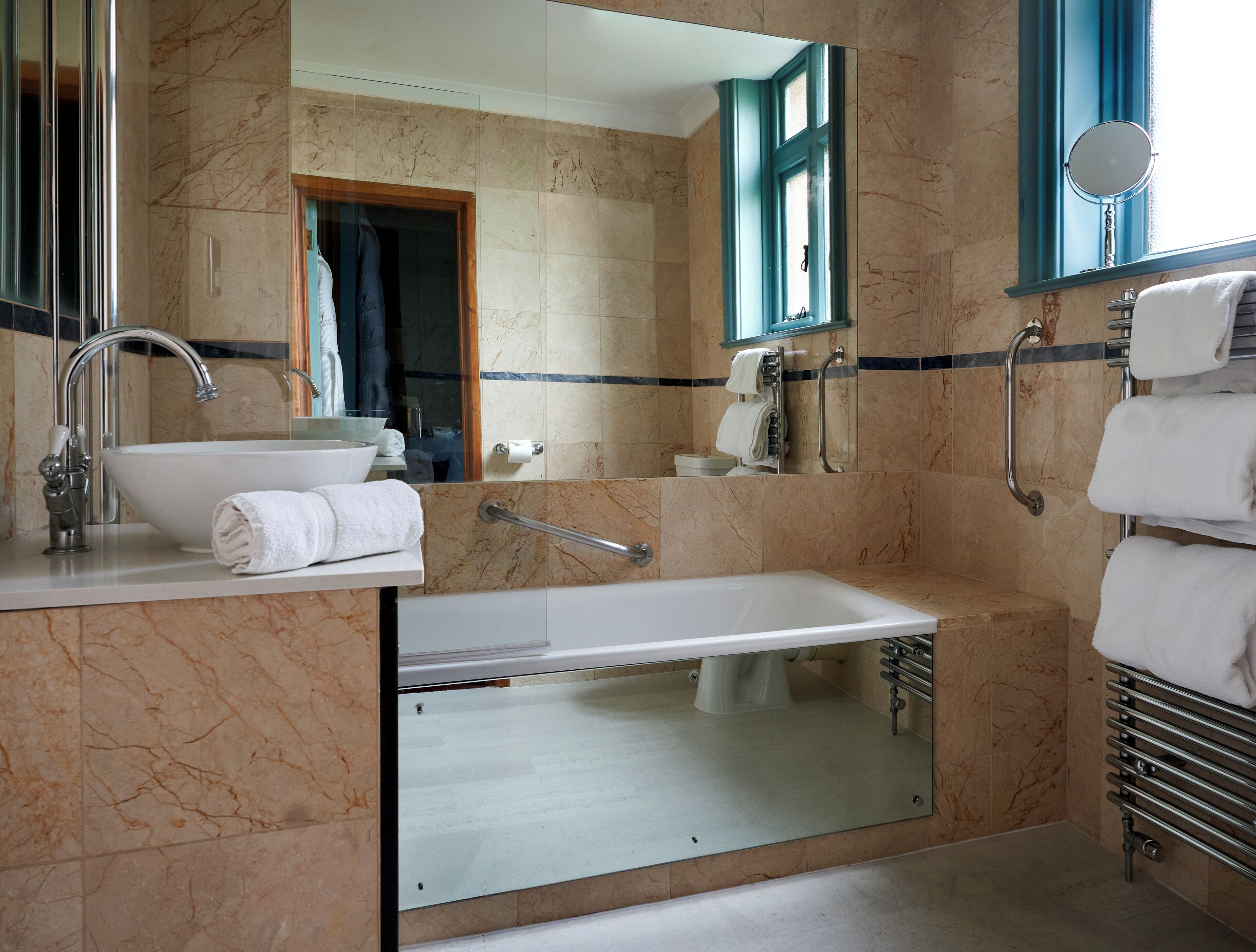 A modern bathroom with a sink, mirror, and bathtub.