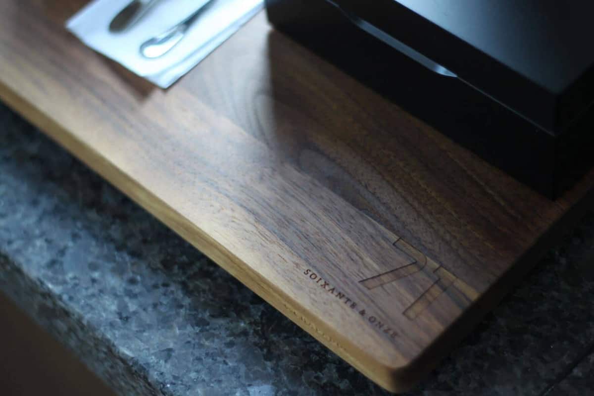 A wooden surface with engraved text and a metal object.