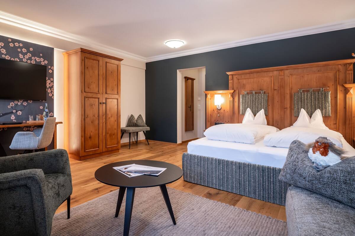 Una habitación moderna con una cama, un escritorio y una televisión.