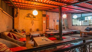 A cozy restaurant with brick walls, wooden ceiling, and comfortable seating. - Hotel Encounter Nepal (Kathmandu)