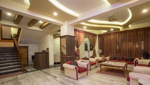 A spacious living area with a marble floor, a staircase, and a sofa set. - Hotel Encounter Nepal (Kathmandu)
