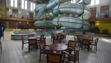 Relax and socialize in this vibrant indoor space featuring a central water slide and comfortable dining areas.