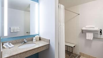 Un baño con lavabo, espejo y zona de ducha.