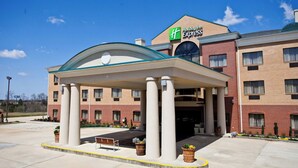 A Holiday Inn Express building with a covered entrance, columns, and a brick facade. - Holiday Inn Express Clanton by IHG (Clanton)