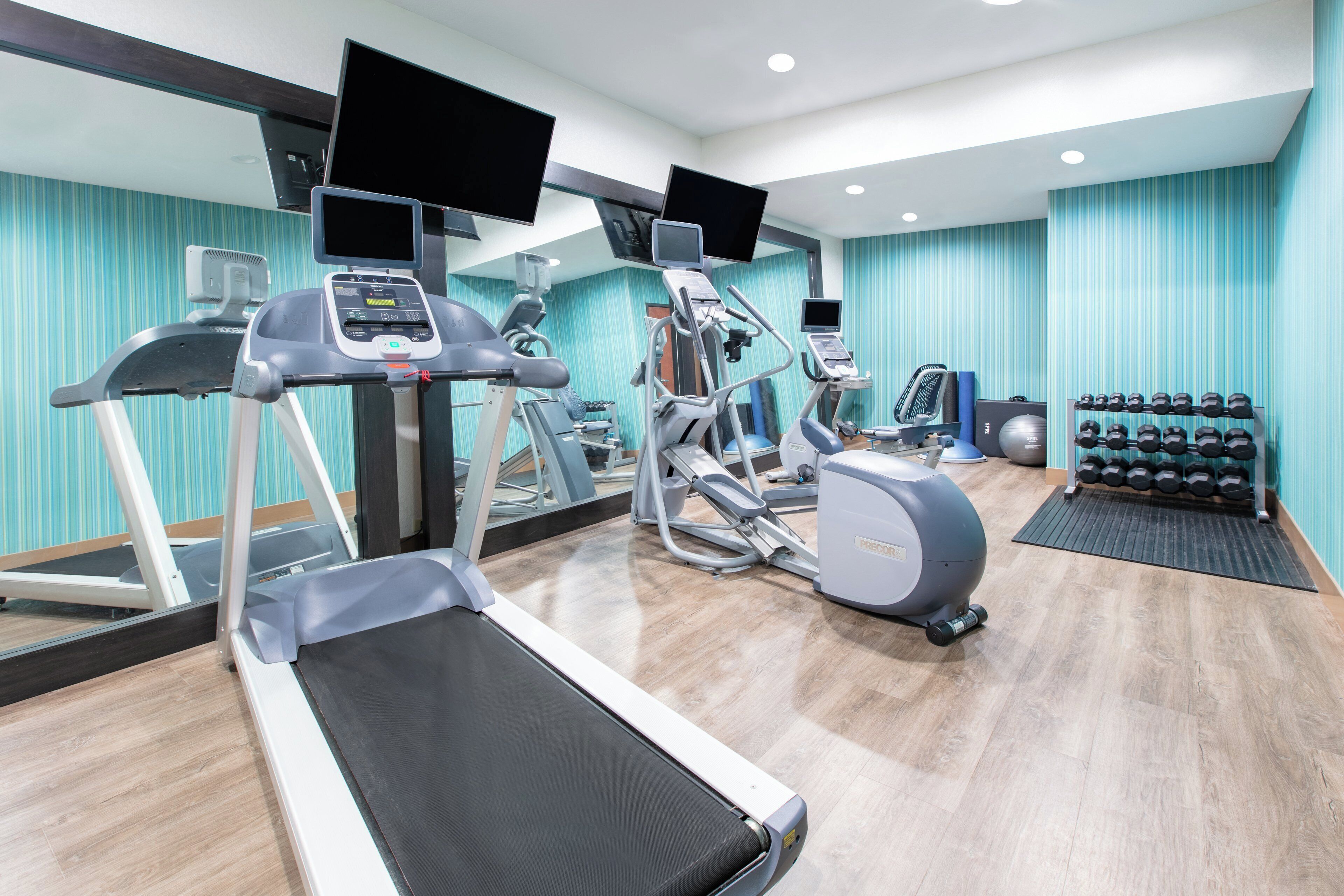 A gym with treadmills, elliptical machines, and a rowing machine.