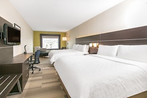 Une chambre d’hôtel avec deux lits, un bureau, une chaise, une télévision et une fenêtre donnant sur un beau paysage.