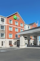 Edificio di un Holiday Inn Express con ingresso ben visibile, facciata in pietra e area di parcheggio con posti delimitati.