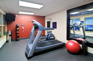 Stay active on the go with a fully equipped fitness room featuring a treadmill, exercise ball, and mirror.