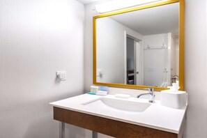 Bathroom features a sink, mirror, and shower area with a towel.