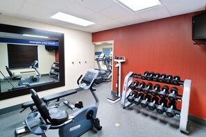Stay fit on the go with our fully equipped gym featuring a stationary bike, elliptical trainer, and dumbbells.