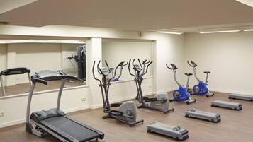 A gym with treadmills, elliptical machines, and step platforms.