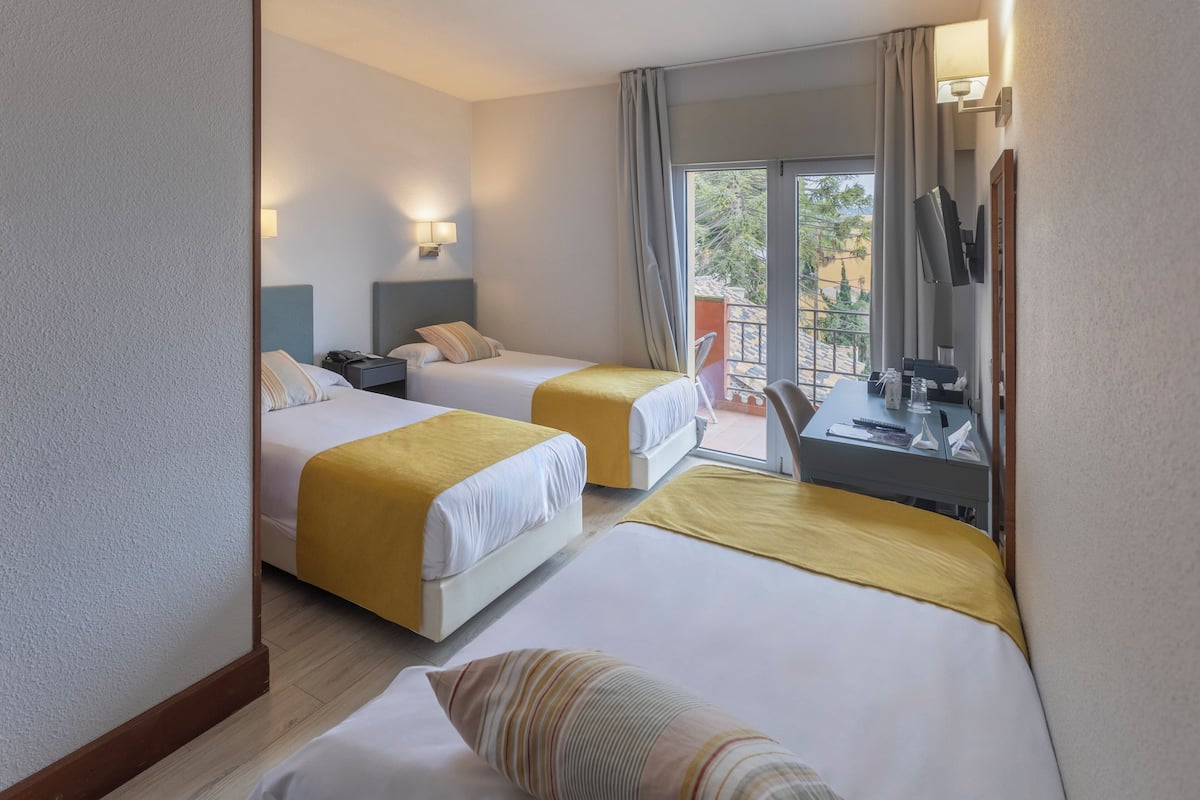 Driepersoonskamer, balkon | Een minibar, een kluis op de kamer, een bureau, verduisterende gordijnen