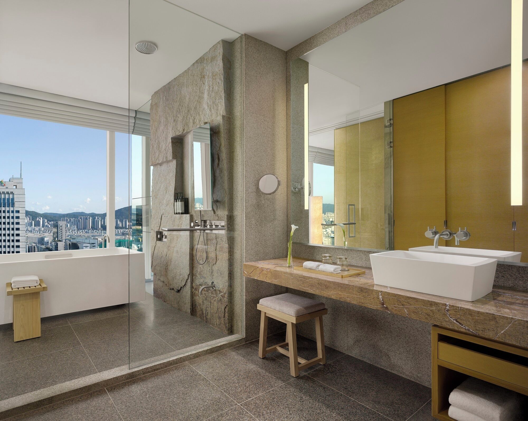 A modern bathroom with a large mirror, a bathtub, and a shower.