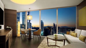 A modern living room with a city view, a round table, a sofa, and a dining area with chairs. - Park Hyatt Seoul (Seoul)