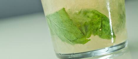 Un verre de boisson fraîche, garnie d’une tranche de citron vert et de quelques feuilles de menthe.