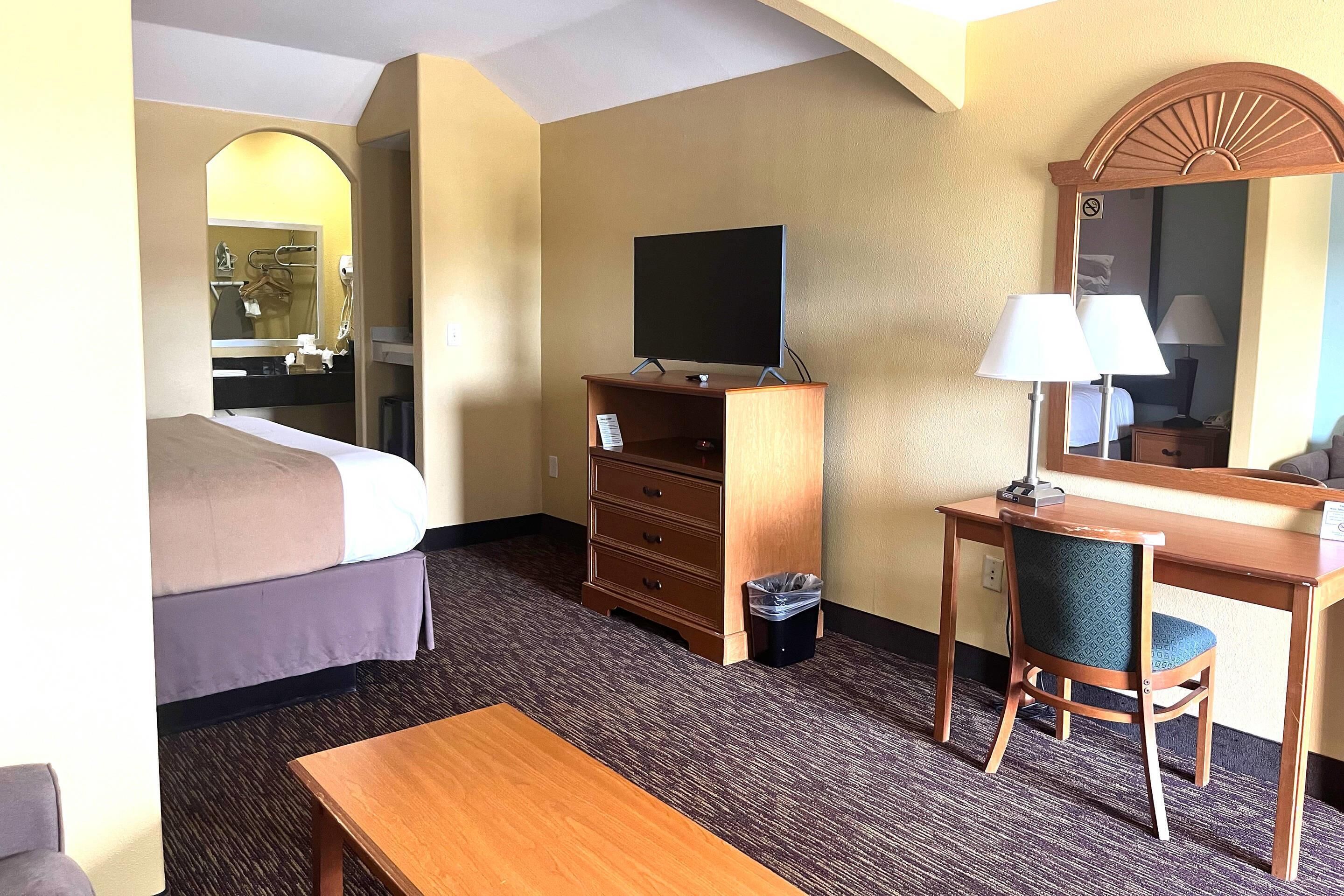 Escritorio, tabla de planchar con plancha, ropa de cama y despertador 