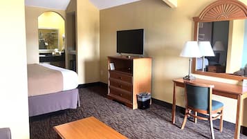 Escritorio, tabla de planchar con plancha, ropa de cama y despertador