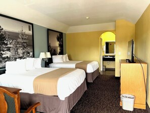 Escritorio, tabla de planchar con plancha, ropa de cama y despertador 