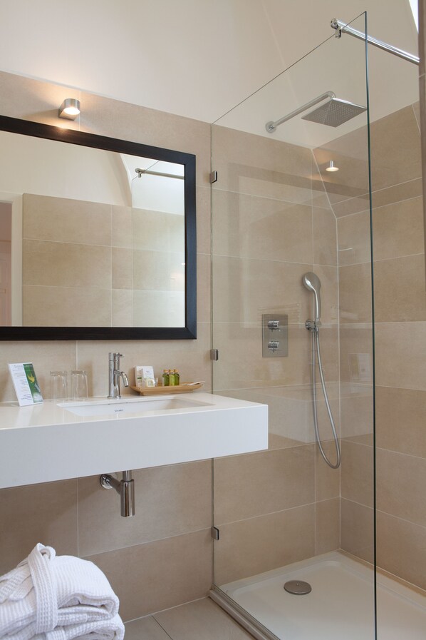 A modern bathroom with a glass-enclosed shower, a white sink, and a mirror above it. - Domaine de la Tortinière (Veigne)