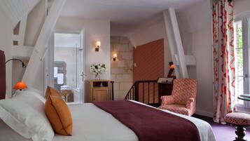 Un dormitorio con cama, una silla, una mesita y una escalera que da a un espacio exterior.