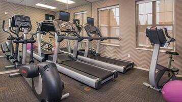 A gym with treadmills, elliptical machines, and a stationary bike.