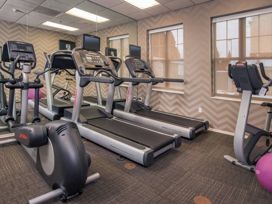 A gym with treadmills, elliptical machines, and a stationary bike.