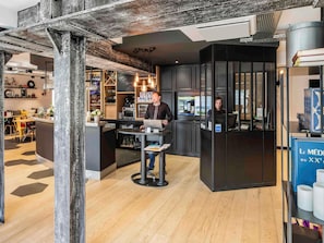 Ein modernes Interieur mit Barbereich, einem Tresen mit Laptop und einer Sitzecke mit Holzboden.