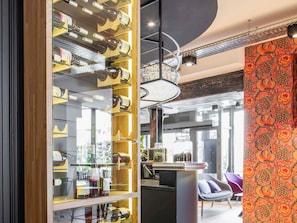 Ein modernes Interieur mit Weinkühler, Bar und einer Wand mit Muster.
