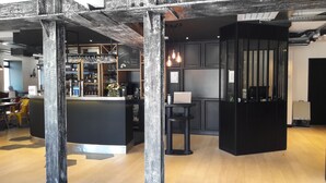 A modern bar area with a counter, stools, and a laptop. - ibis Styles Dinan Centre Ville (Dinan)