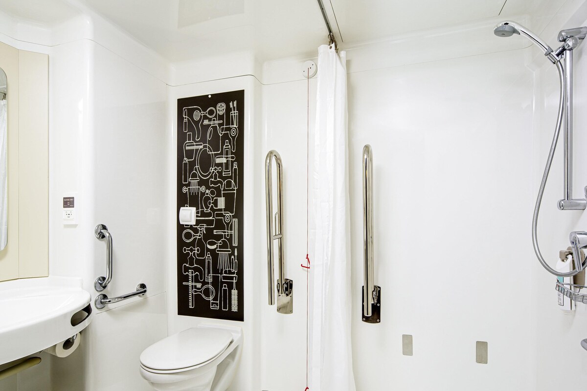Un baño con inodoro, ducha y lavamanos.